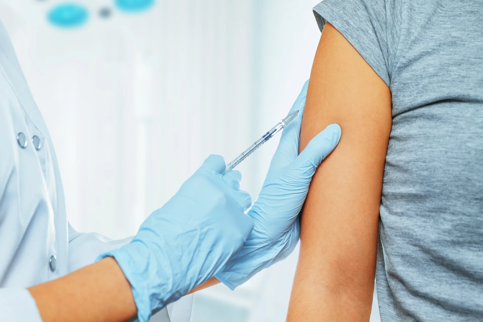 Healthcare professional administering vaccine to patient
